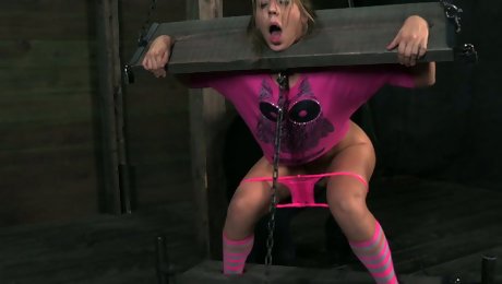 White skank Chastity Lynn is fixed in the pillory and teased